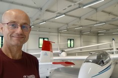 dr inż Robert Jakubowski na tle szybowców w hangarze